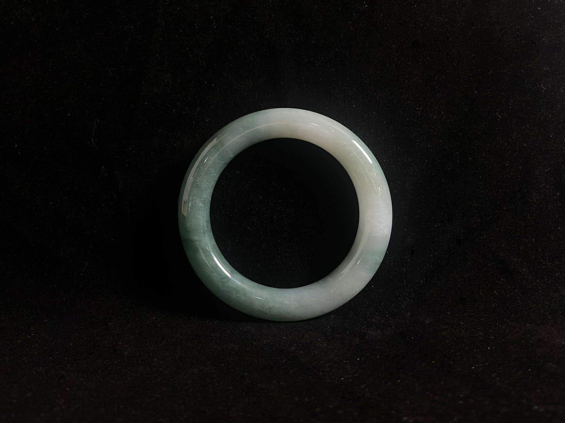 Green jade ring on a black background