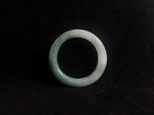 Green jade ring on a black background