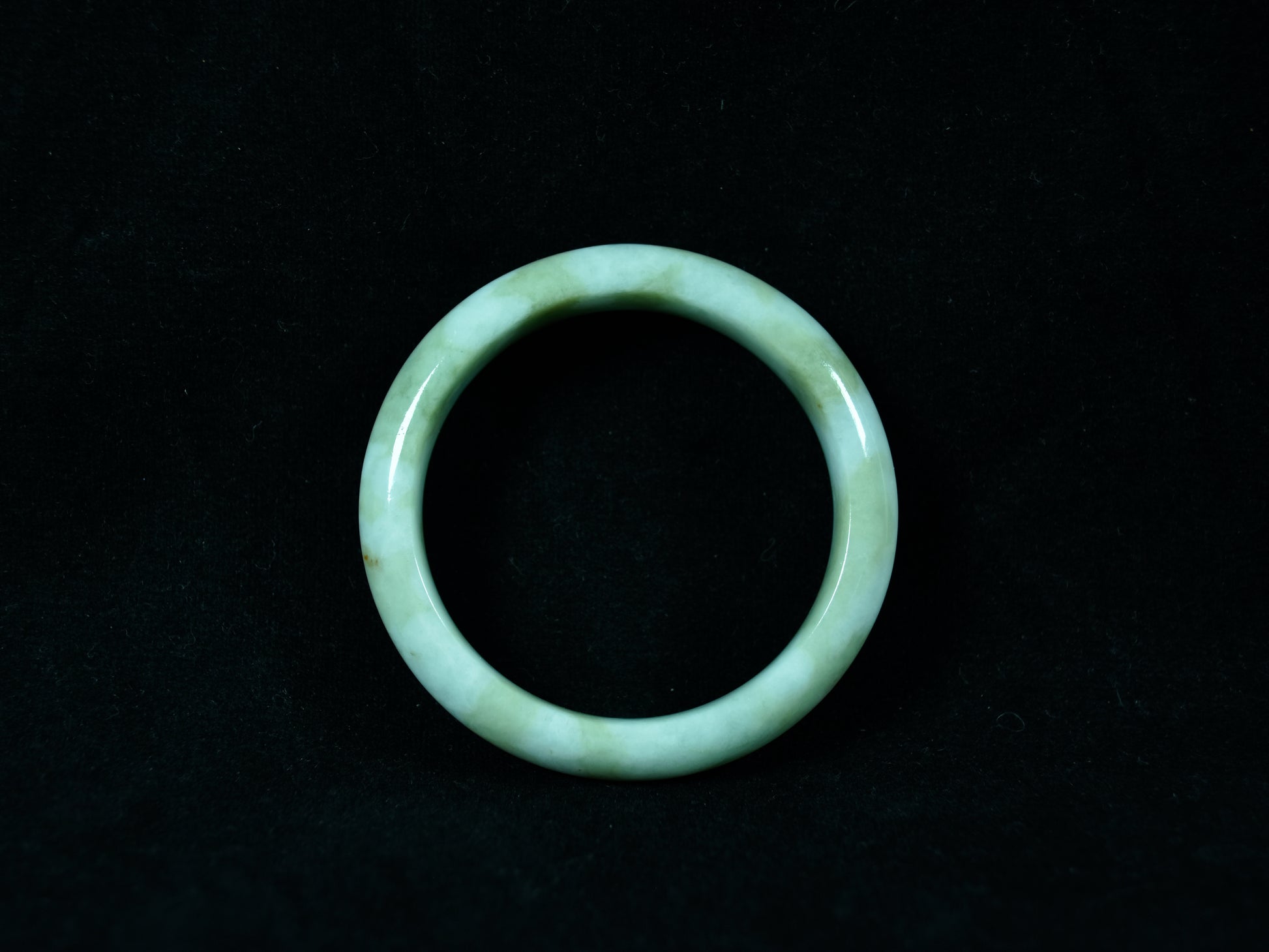 Green jade ring on a black background
