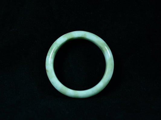 Green jade ring on a black background