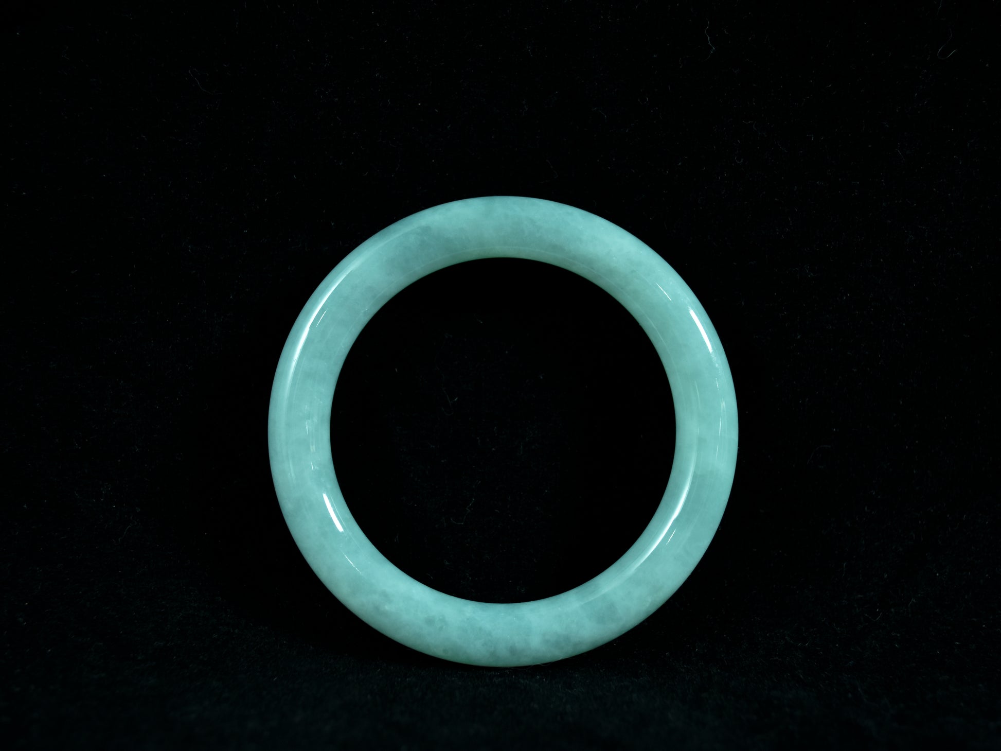 Light blue jade bracelet on a black background