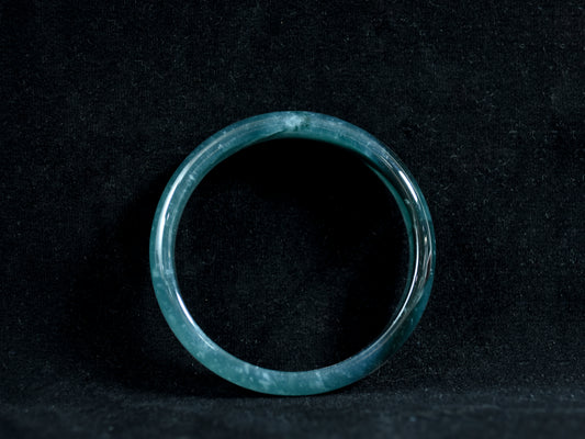Green jade ring on a black background