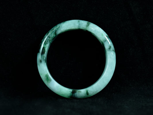 Green jade ring on a black background