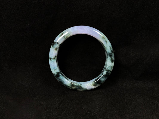 A jadeite bangle with purple and floating ink-green hues.