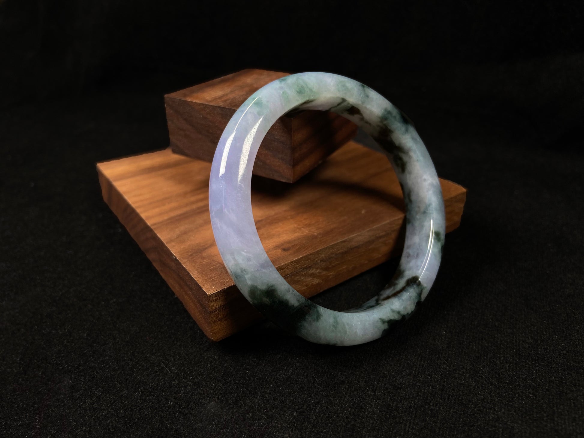 A jadeite bangle with purple and floating ink-green hues.