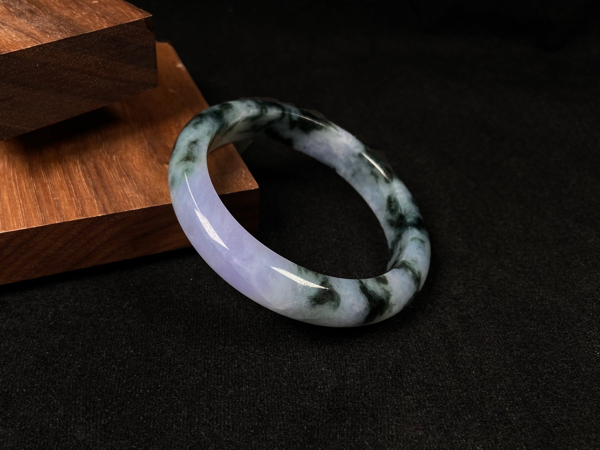 A jadeite bangle with purple and floating ink-green hues.