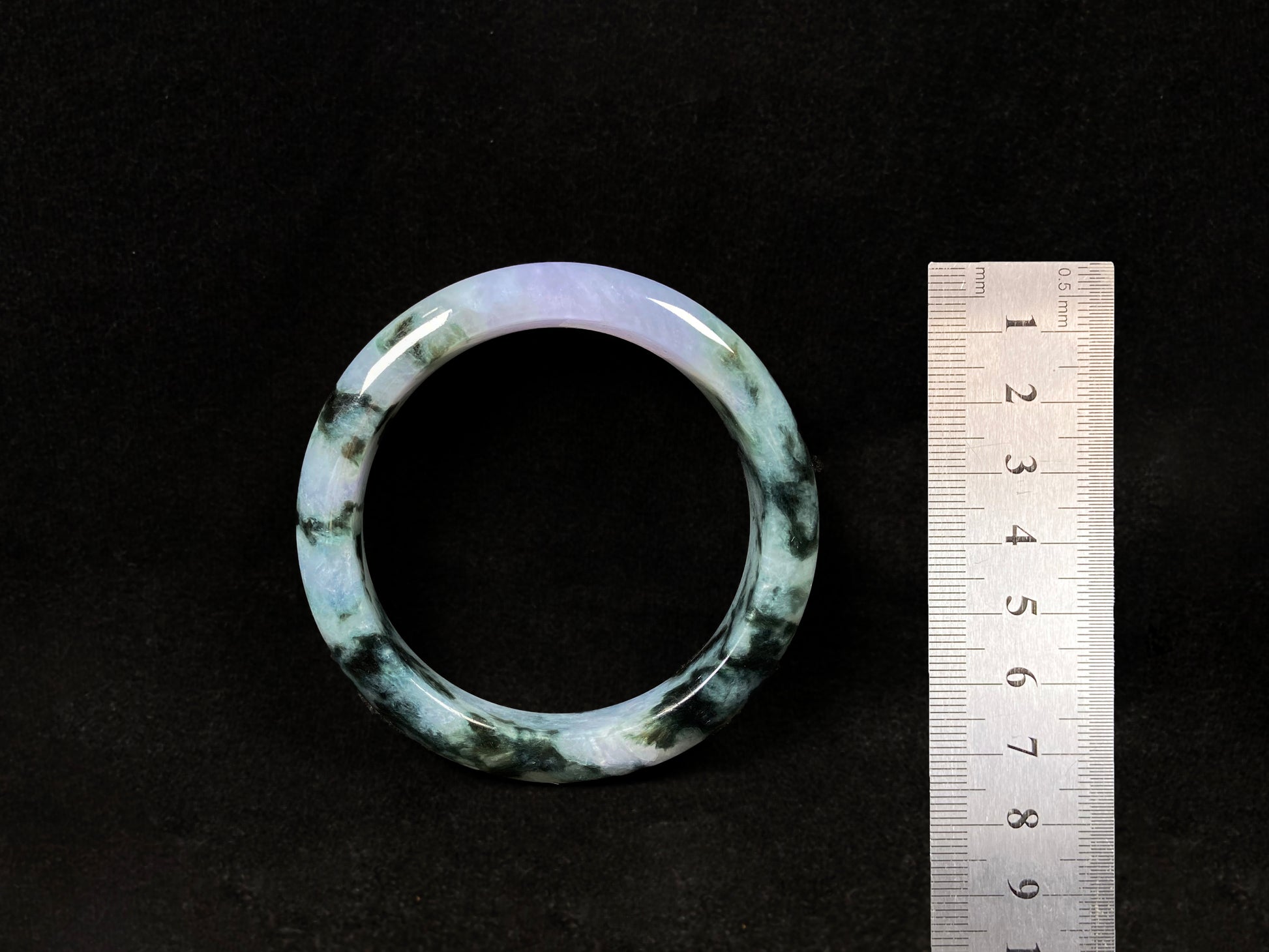 A jadeite bangle with purple and floating ink-green hues.