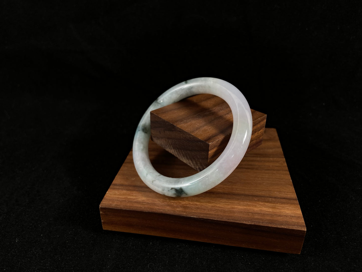 Nestled on wood with a tiny plank inside its circle, this bangle highlights striking moss green and ivory white hues.