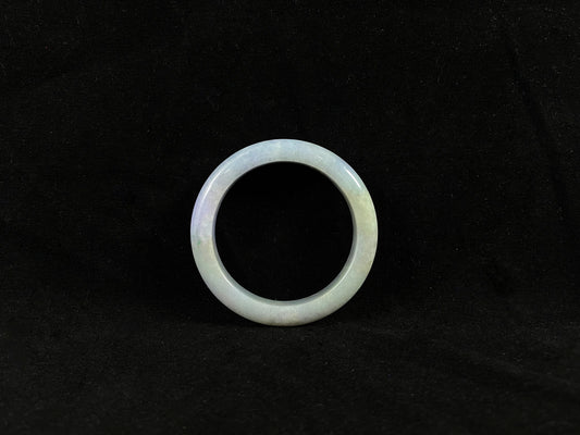 A lavender and green jade bangle sprinkled with sunlit gold specks.