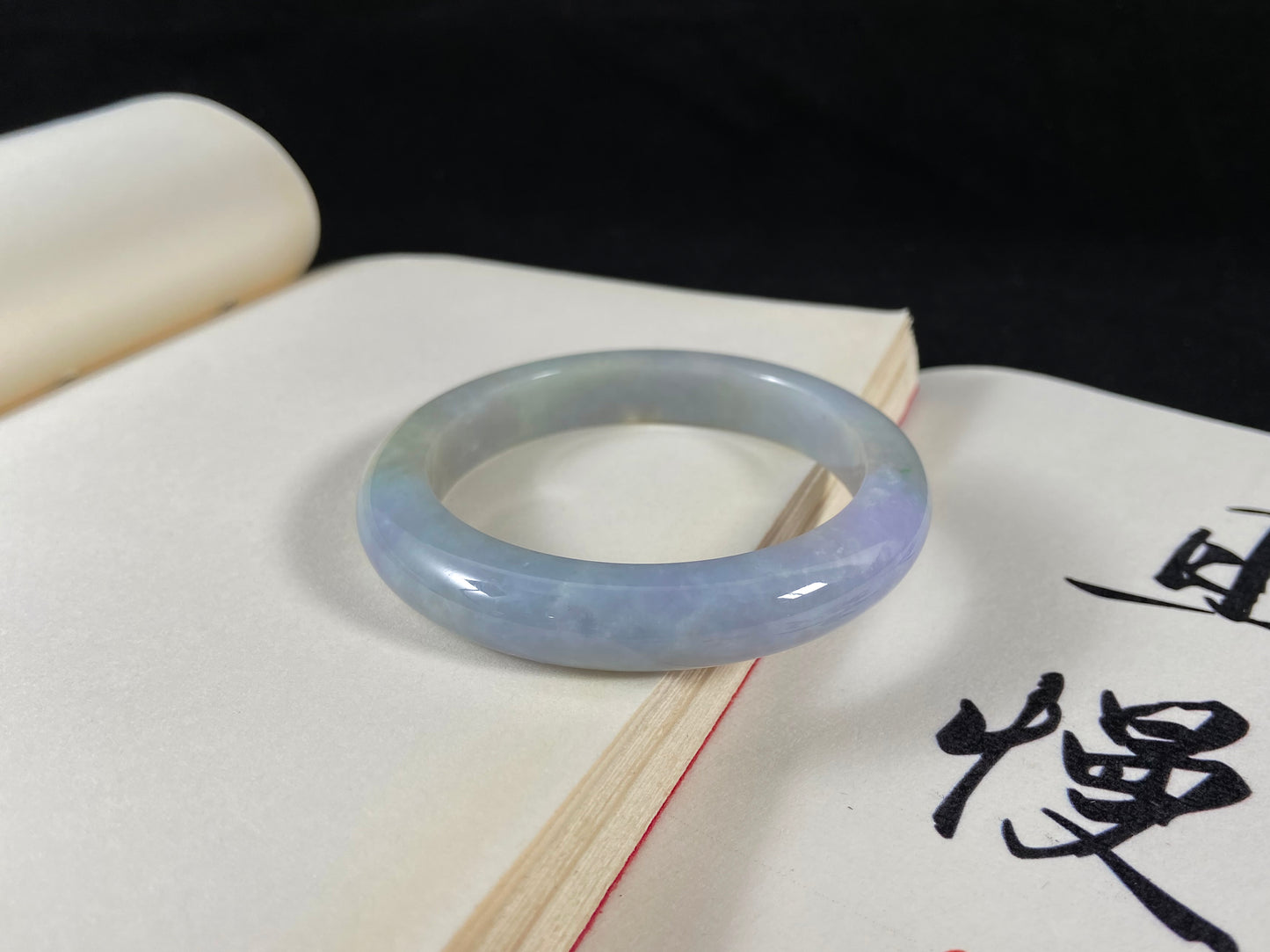 A lavender and green jade bangle sprinkled with sunlit gold specks.