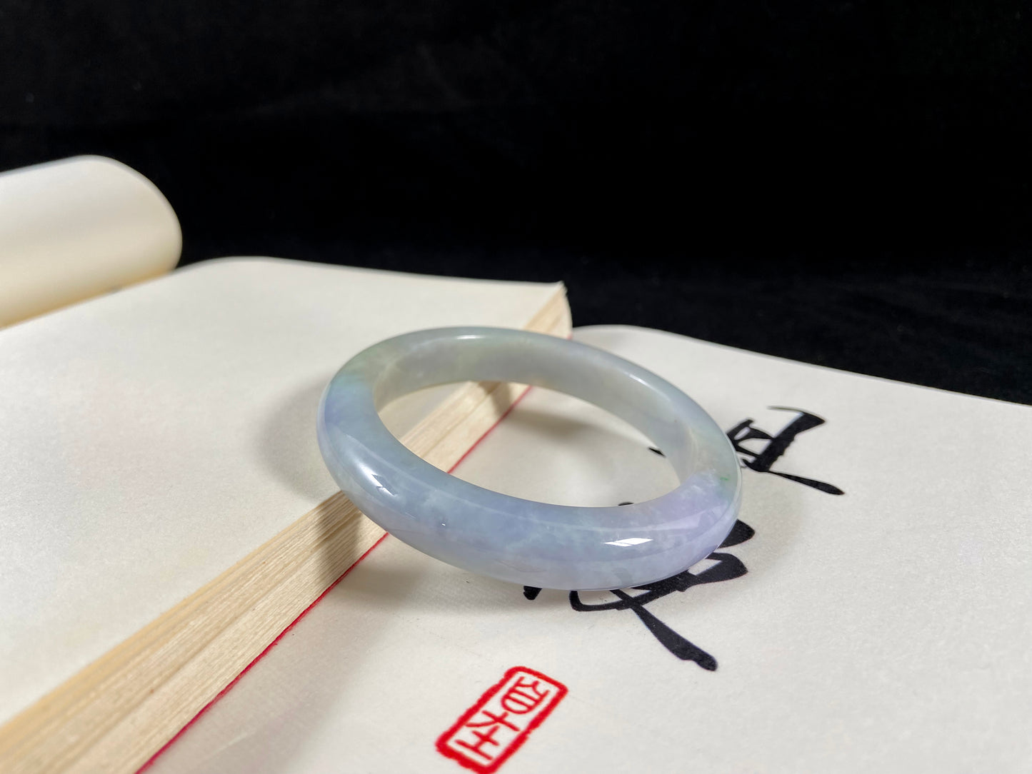 A lavender and green jade bangle sprinkled with sunlit gold specks.