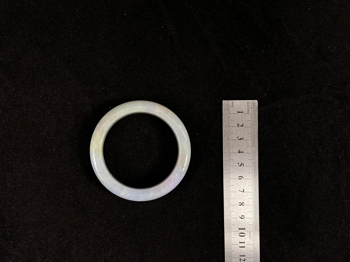 A lavender and green jade bangle sprinkled with sunlit gold specks.