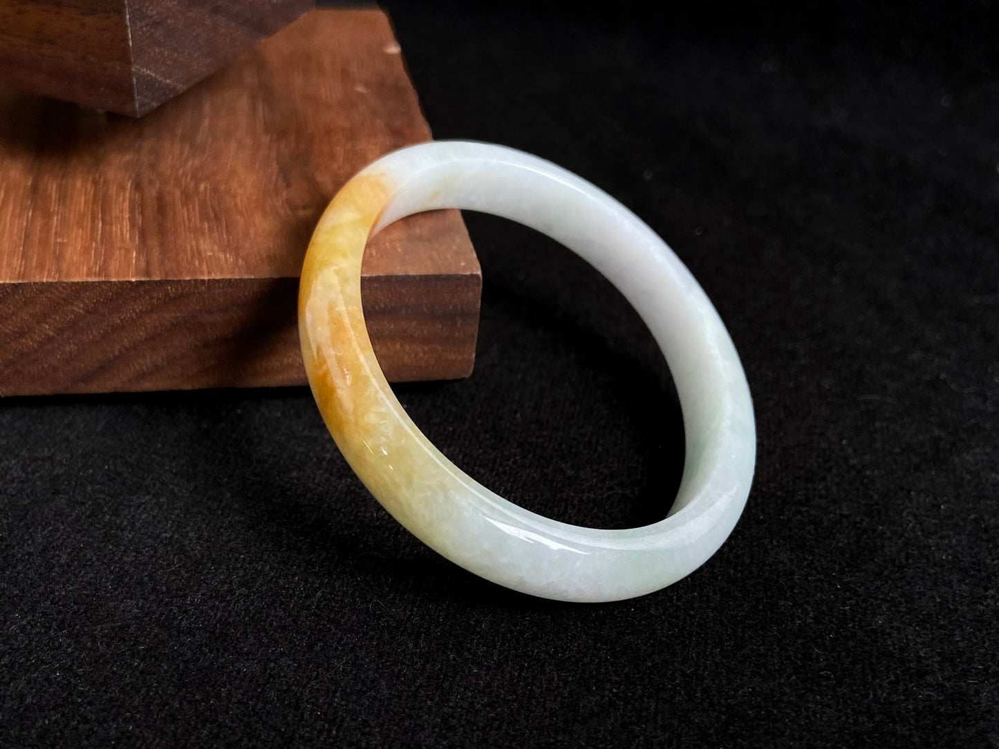 This jade bangle features a creamy white base adorned with delicate gold sprinkles, creating an elegant two tone effect.