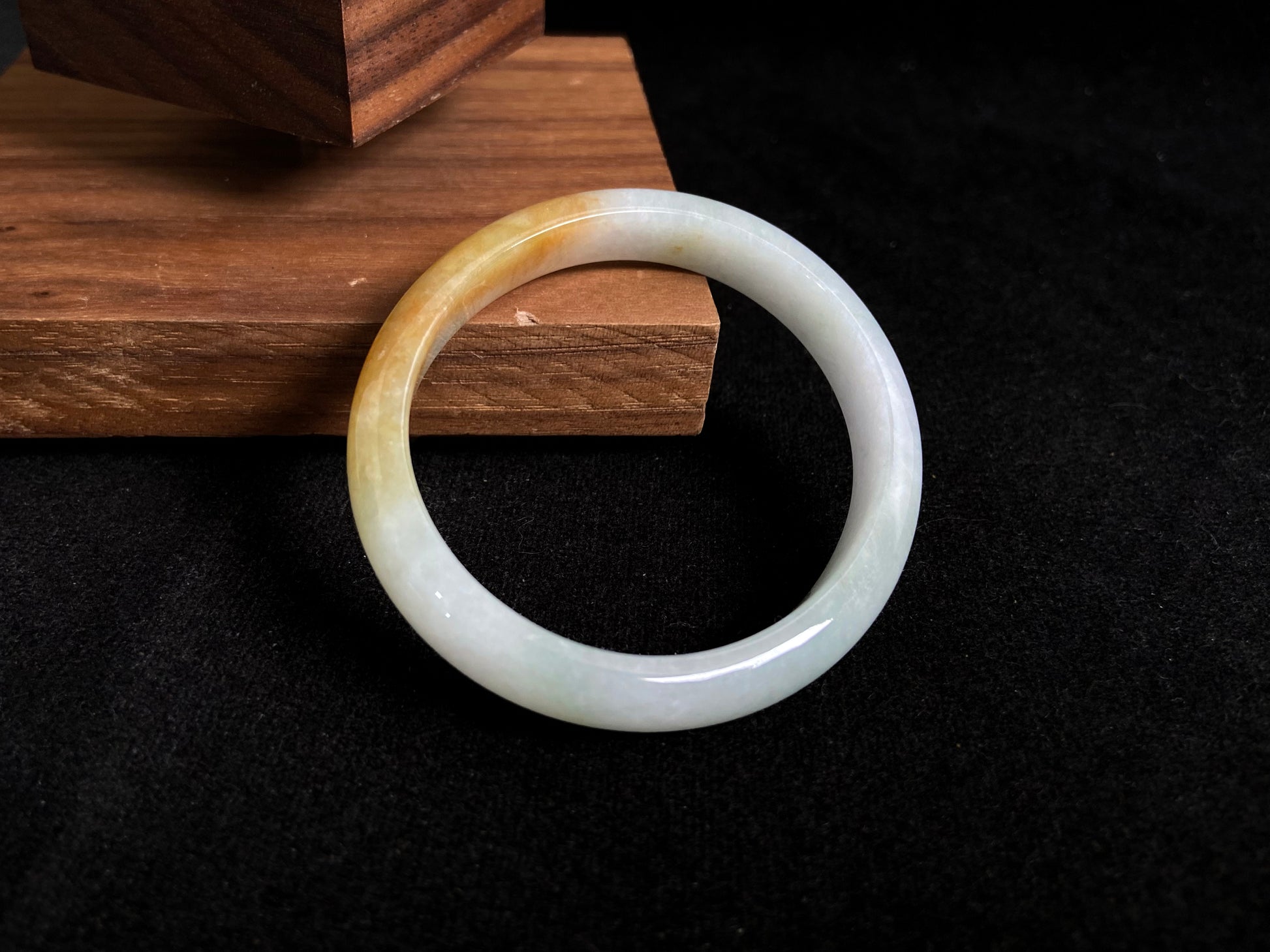 This jade bangle features a creamy white base adorned with delicate gold sprinkles, creating an elegant two tone effect.