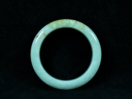 Green jade ring on a black background
