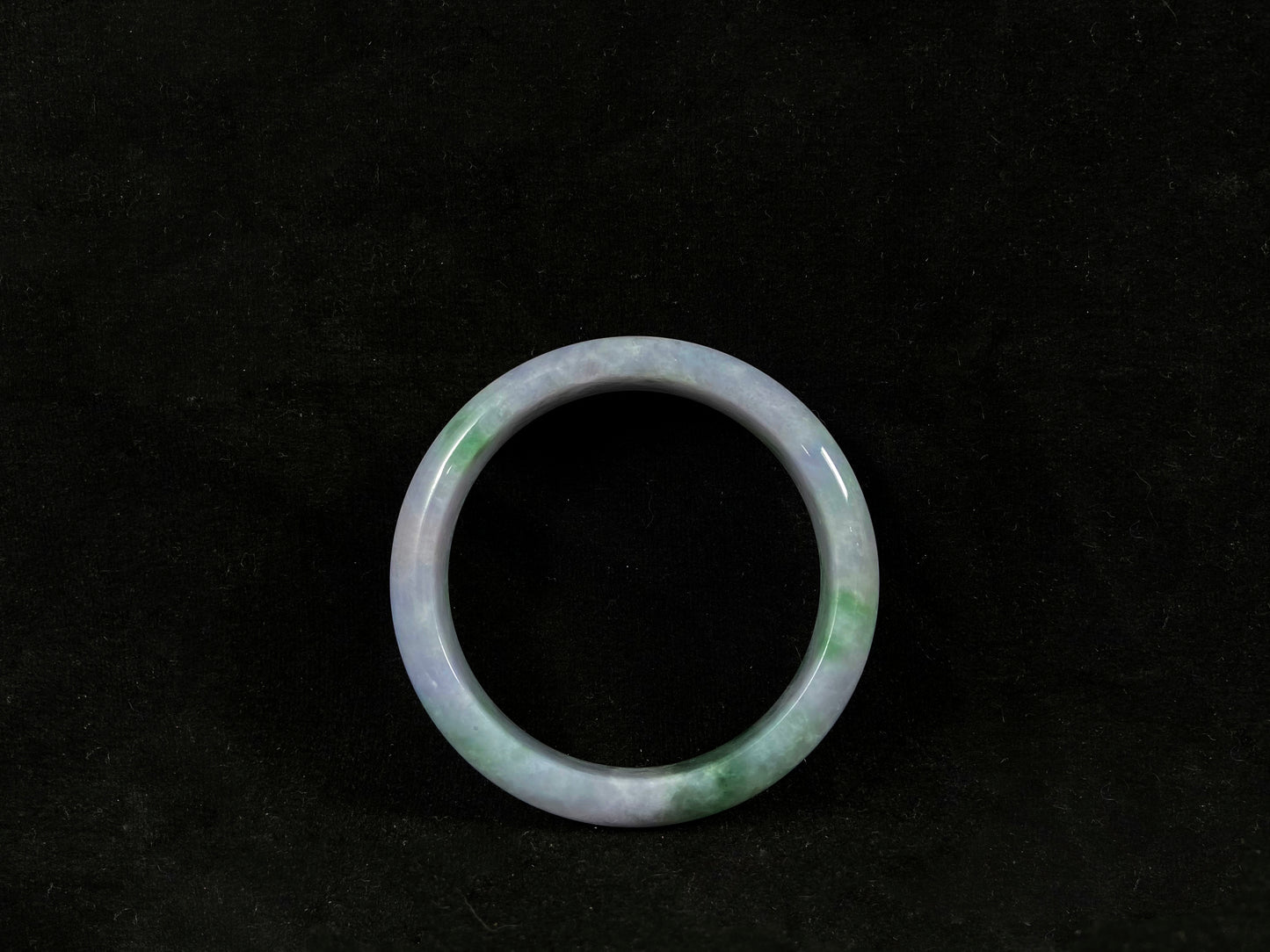 Green jade ring on a black background