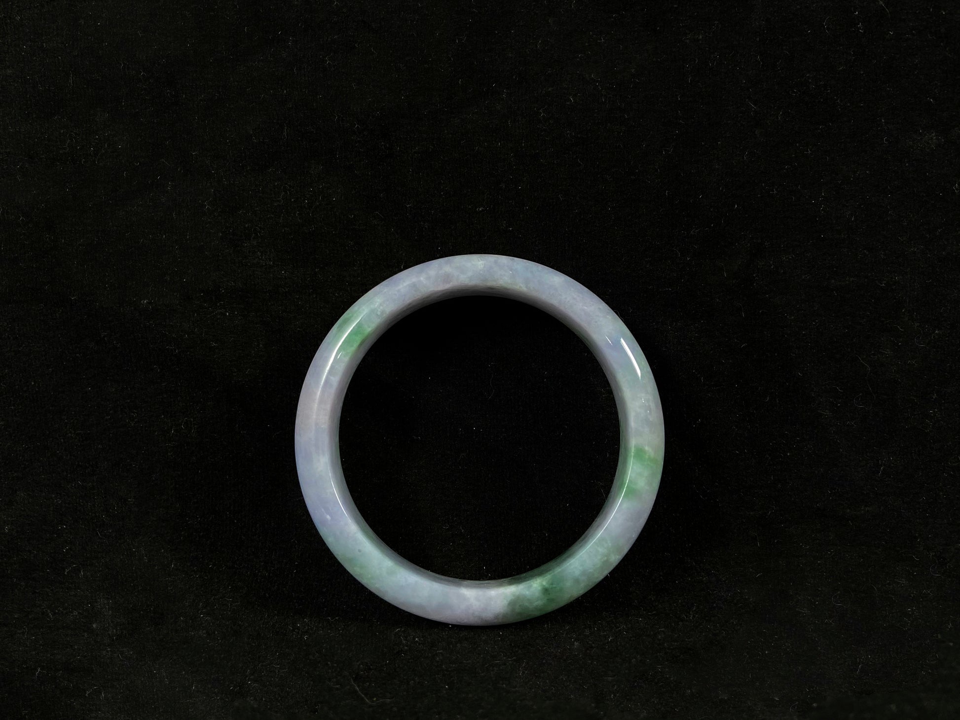Green jade ring on a black background