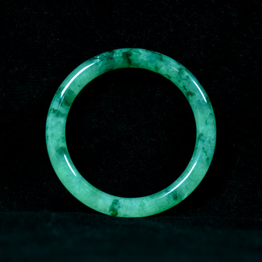 Green jade ring on a black background