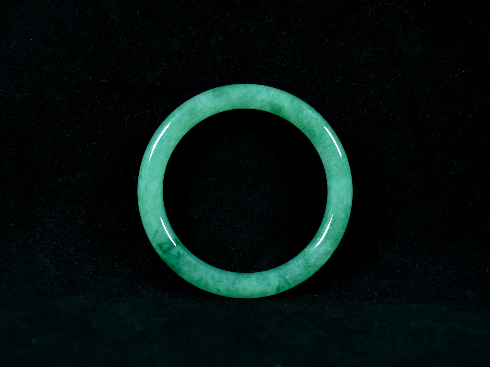 Green jade ring on a black background