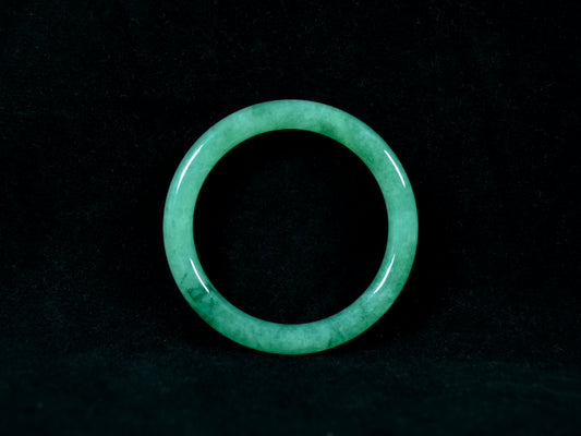 Green jade ring on a black background