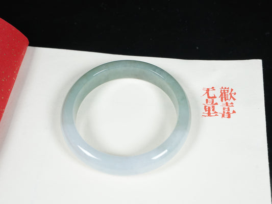 A half white half pale green dual tone  jadeite bangle.