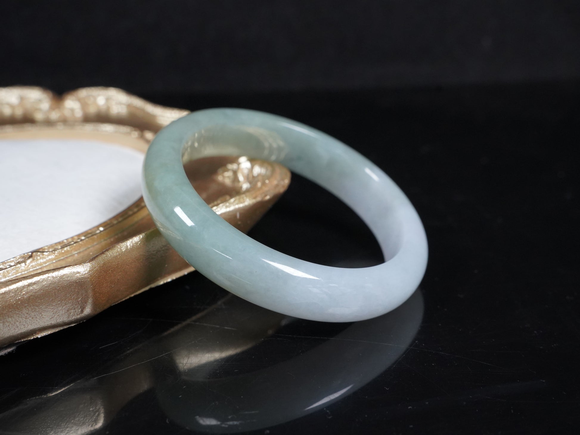 A half white half pale green dual tone  jadeite bangle.