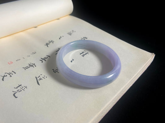 Purple jade ring on a book with Chinese characters