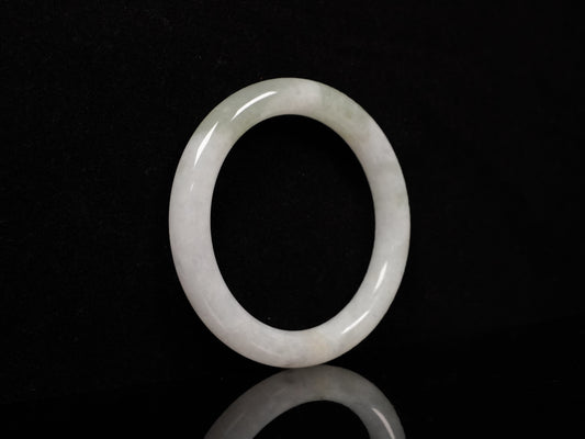 A milky white with soft green veins  jadeite bangle.