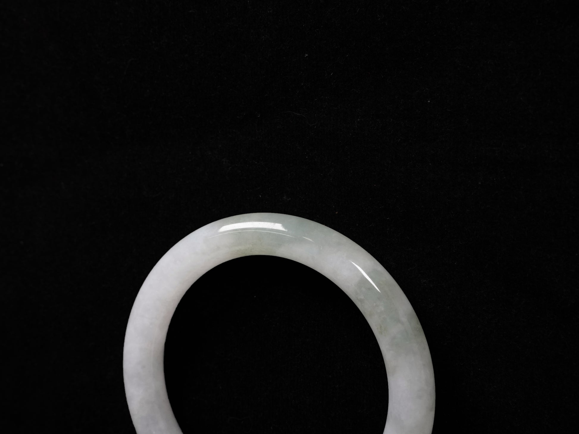 A milky white with soft green veins  jadeite bangle.