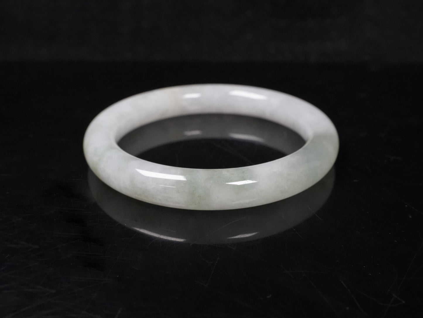 A milky white with soft green veins  jadeite bangle.