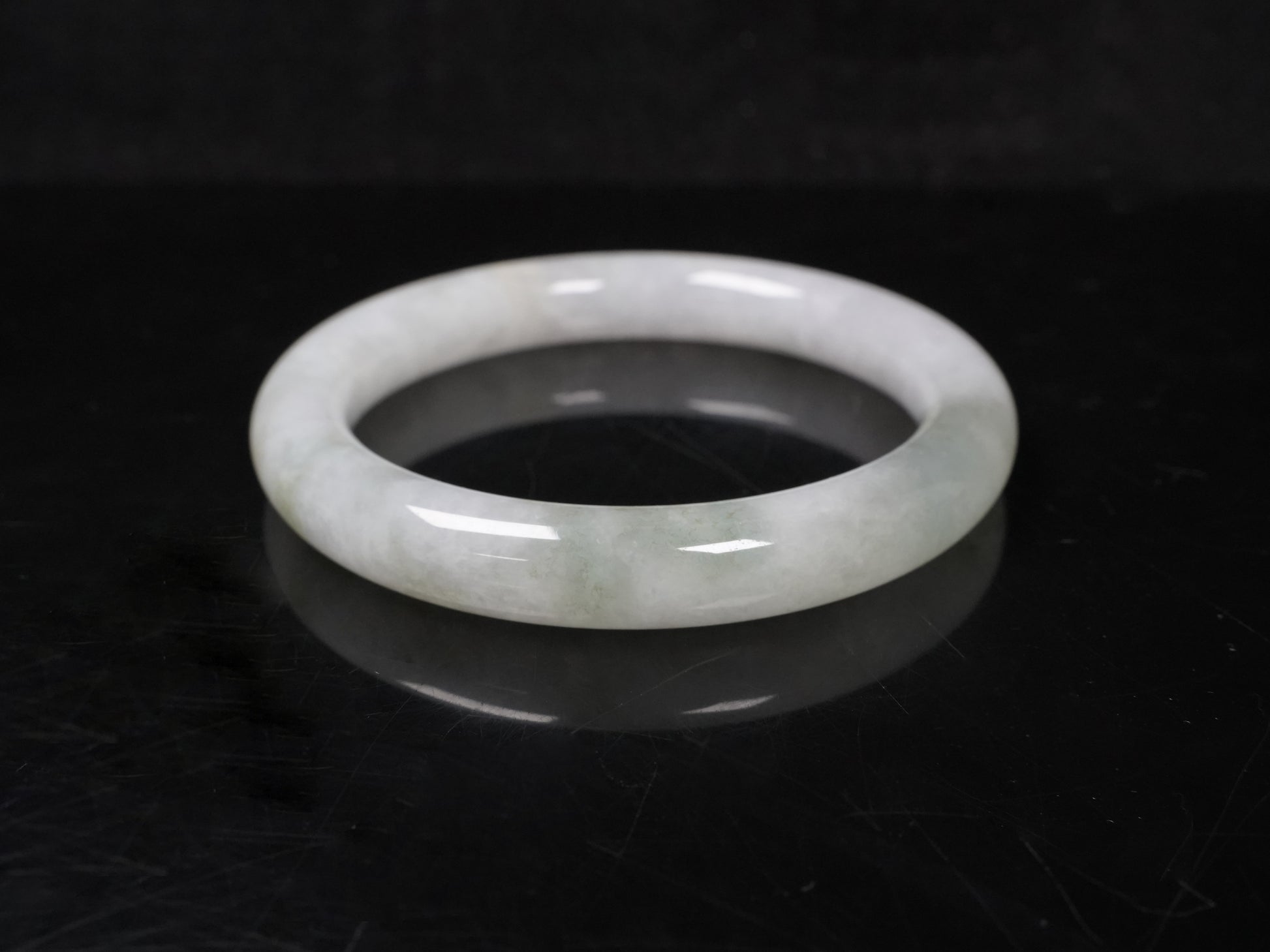 A milky white with soft green veins  jadeite bangle.