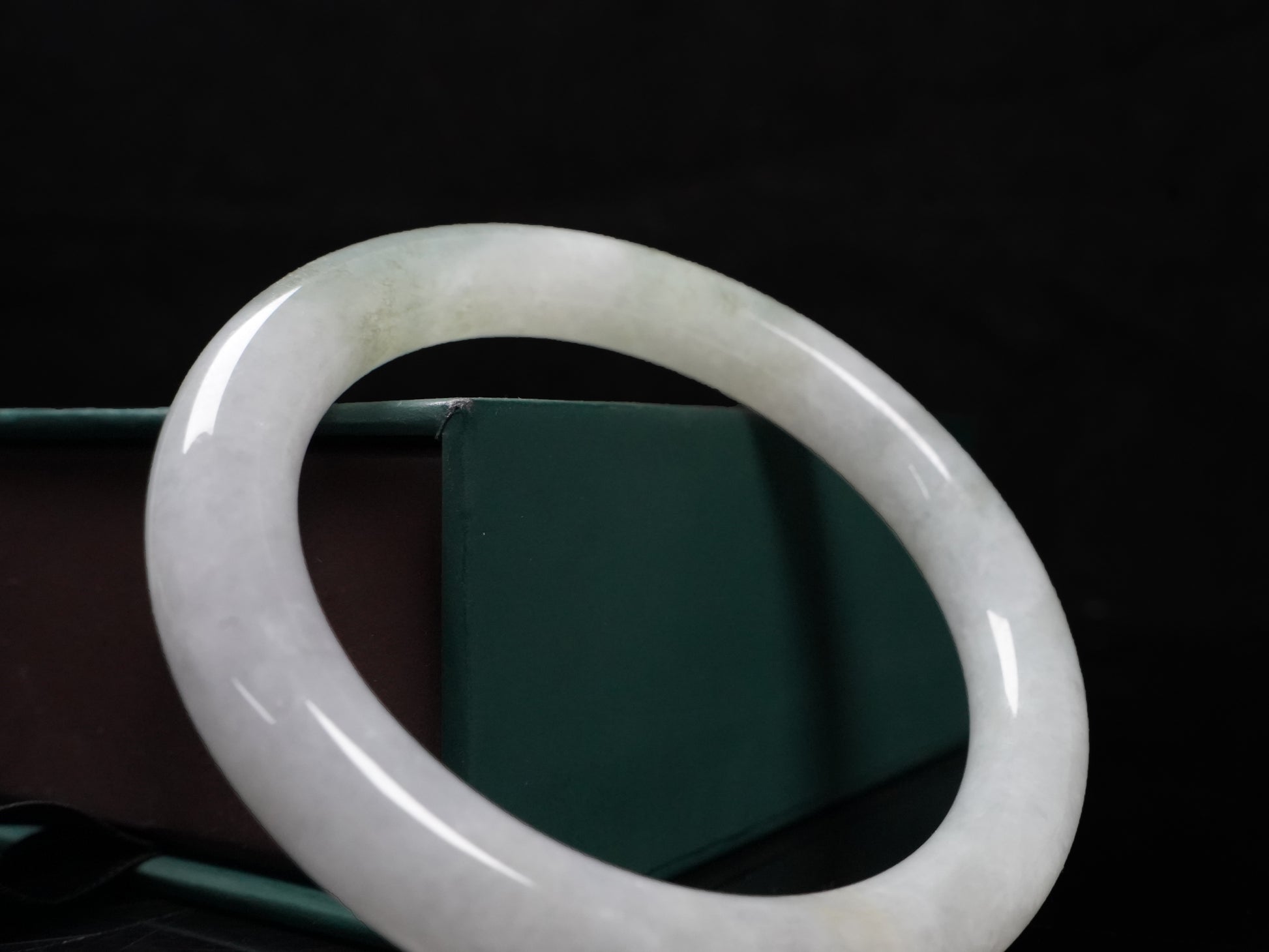 A milky white with soft green veins  jadeite bangle.