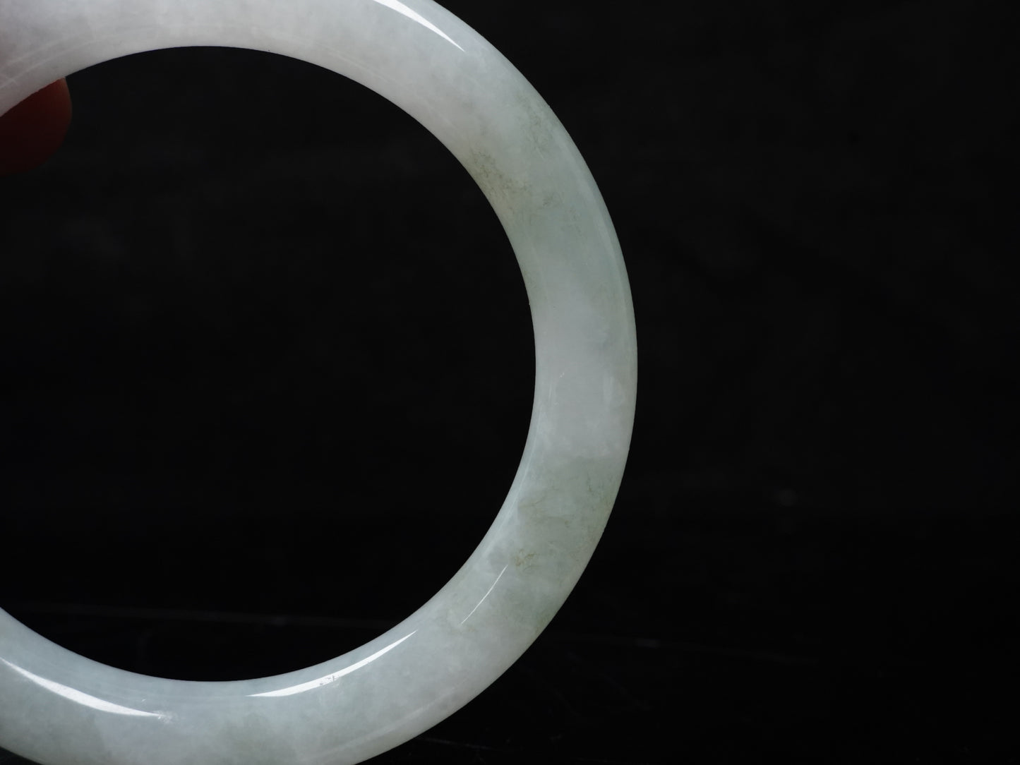 A milky white with soft green veins  jadeite bangle.
