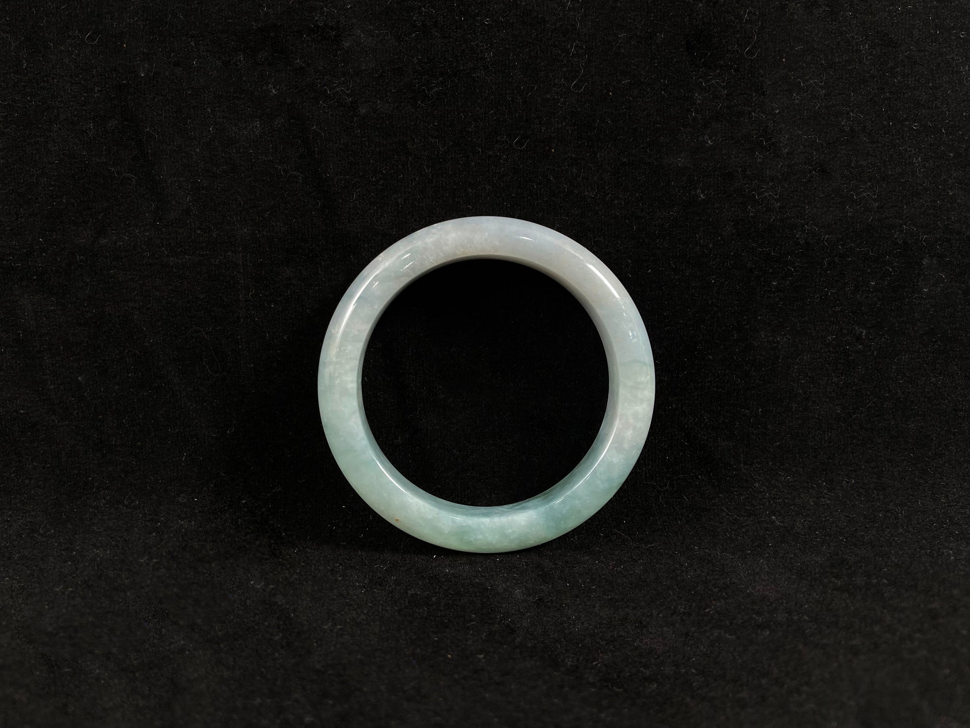 Green jade ring on a black background
