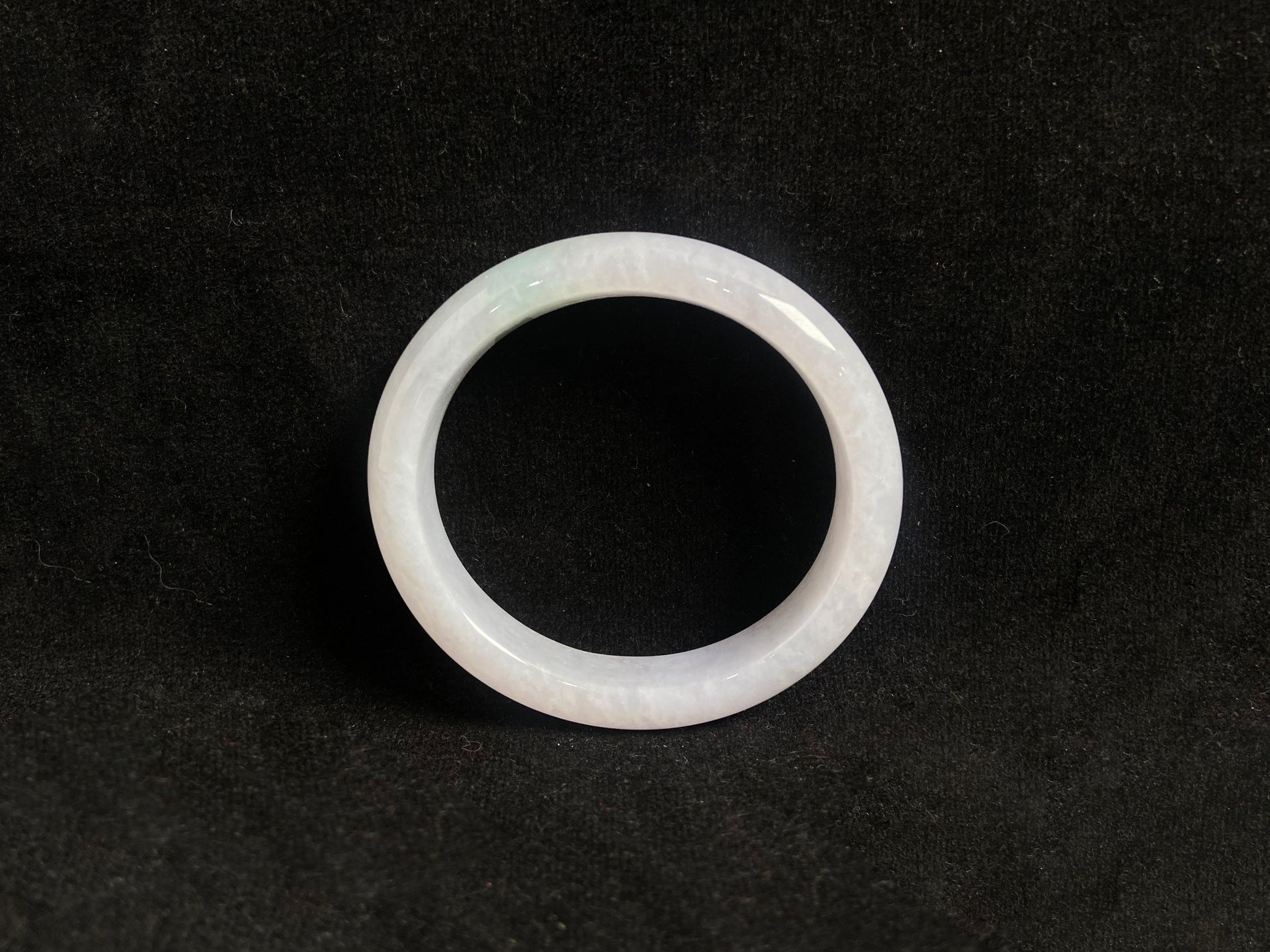 This jade bangle features a creamy white oval shaped Guifei design, known for its elegant and comfortable fit.