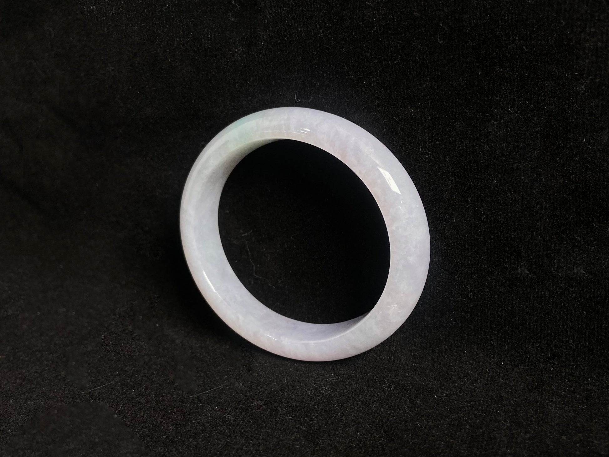 This jade bangle features a creamy white oval shaped Guifei design, known for its elegant and comfortable fit.