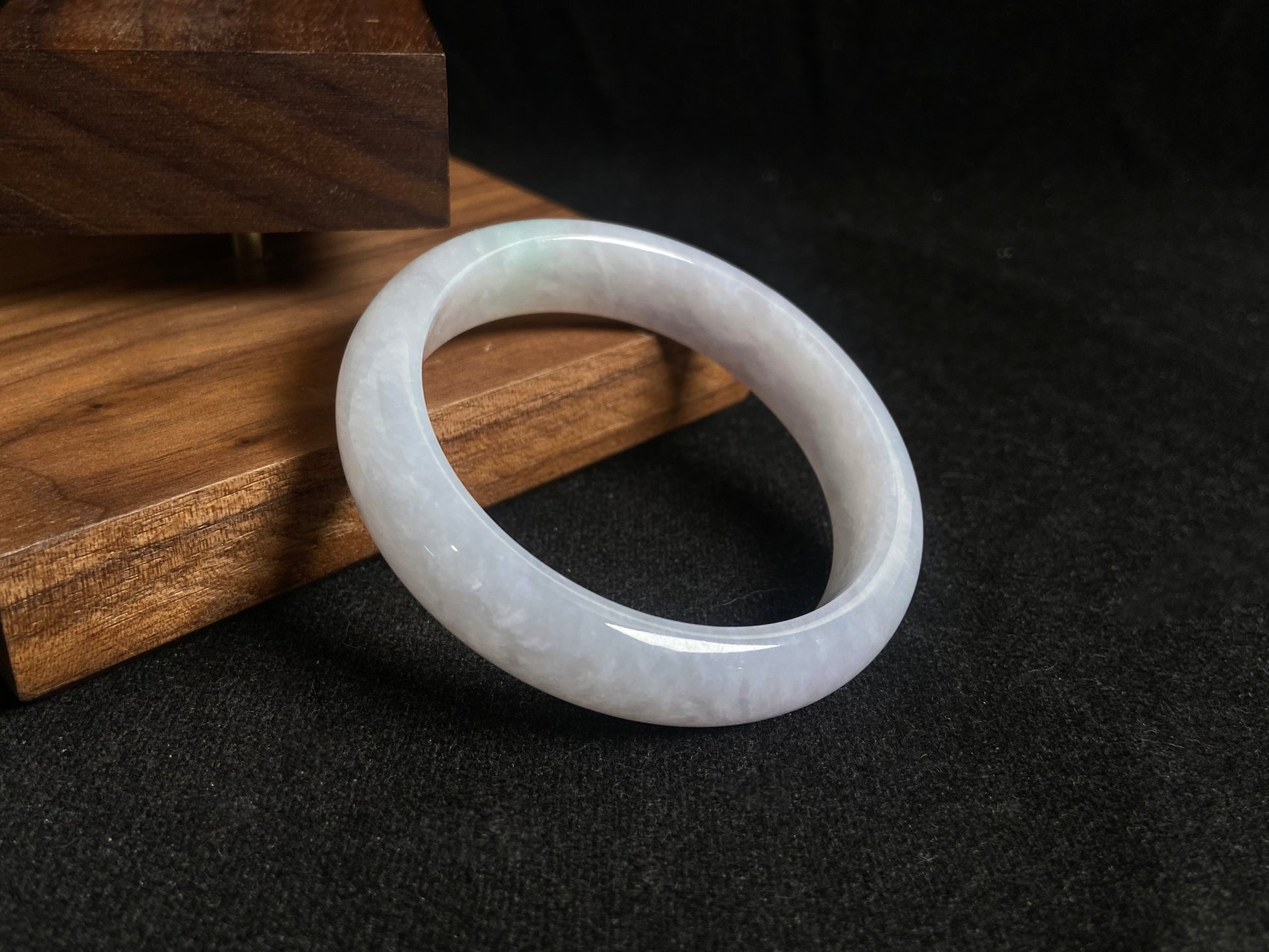 This jade bangle features a creamy white oval shaped Guifei design, known for its elegant and comfortable fit.