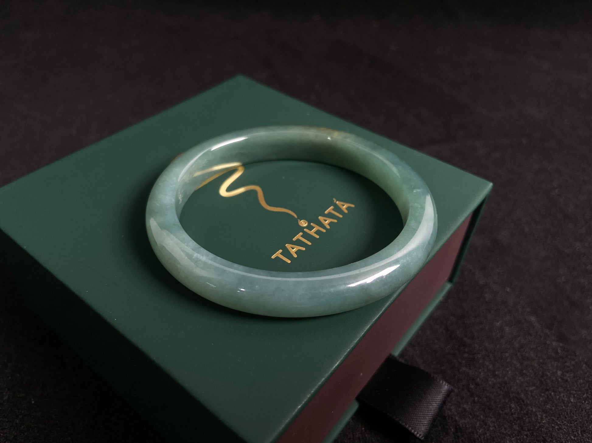 Deep green jade bangle with gold sprinkles.