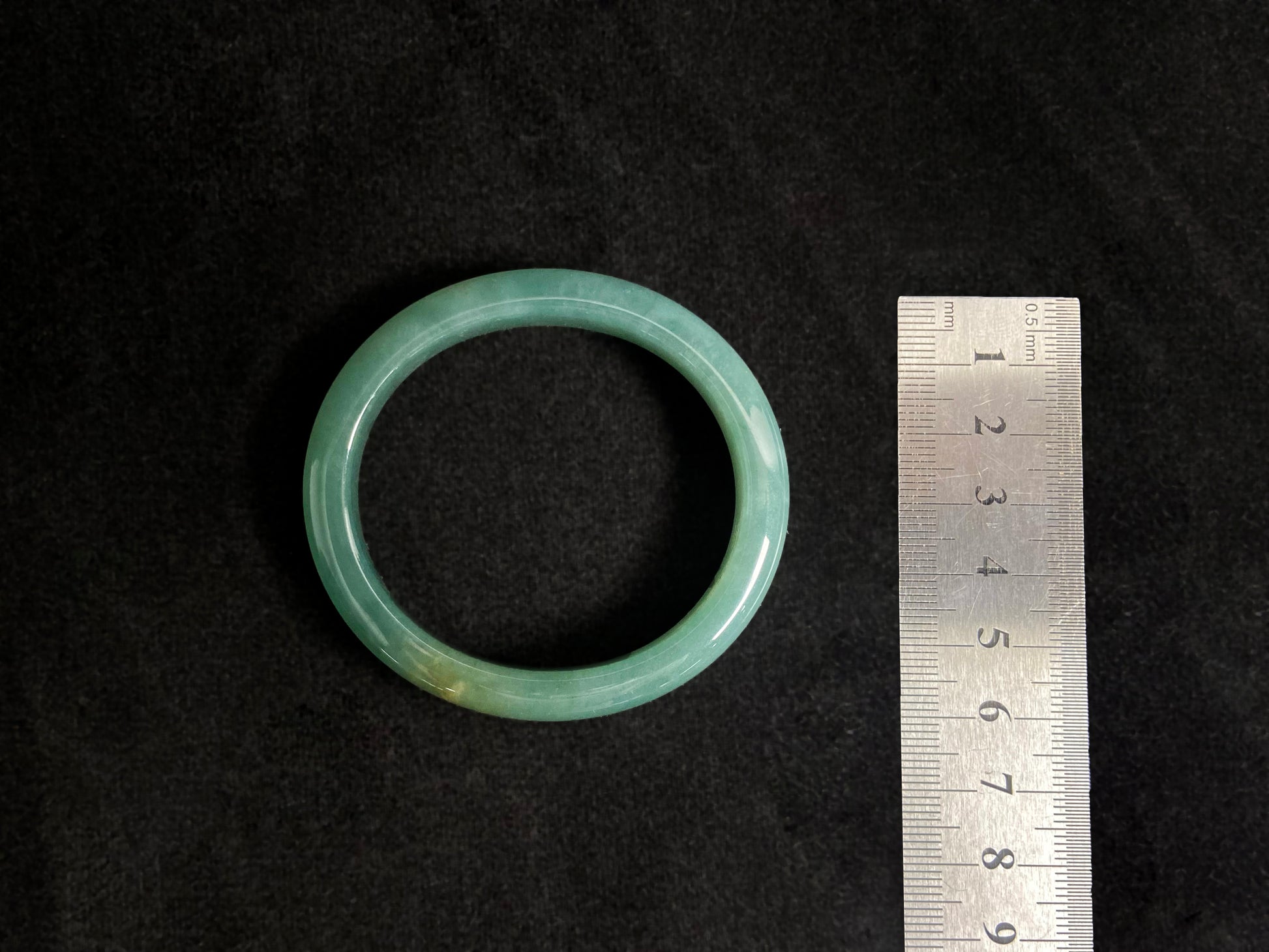 Deep green jade bangle with gold sprinkles.