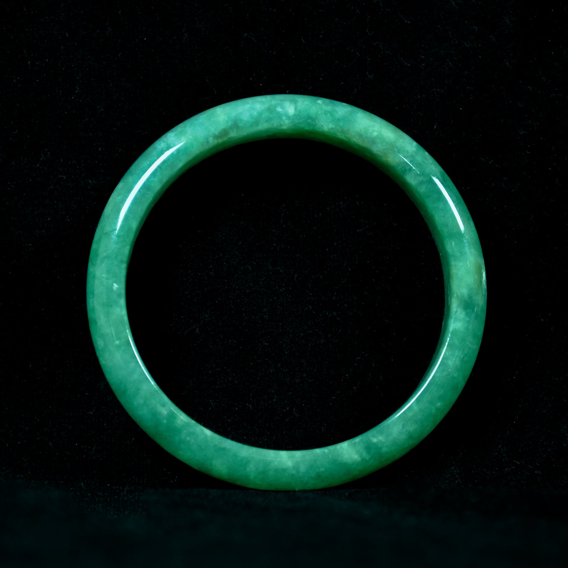 Green jade ring on a black background