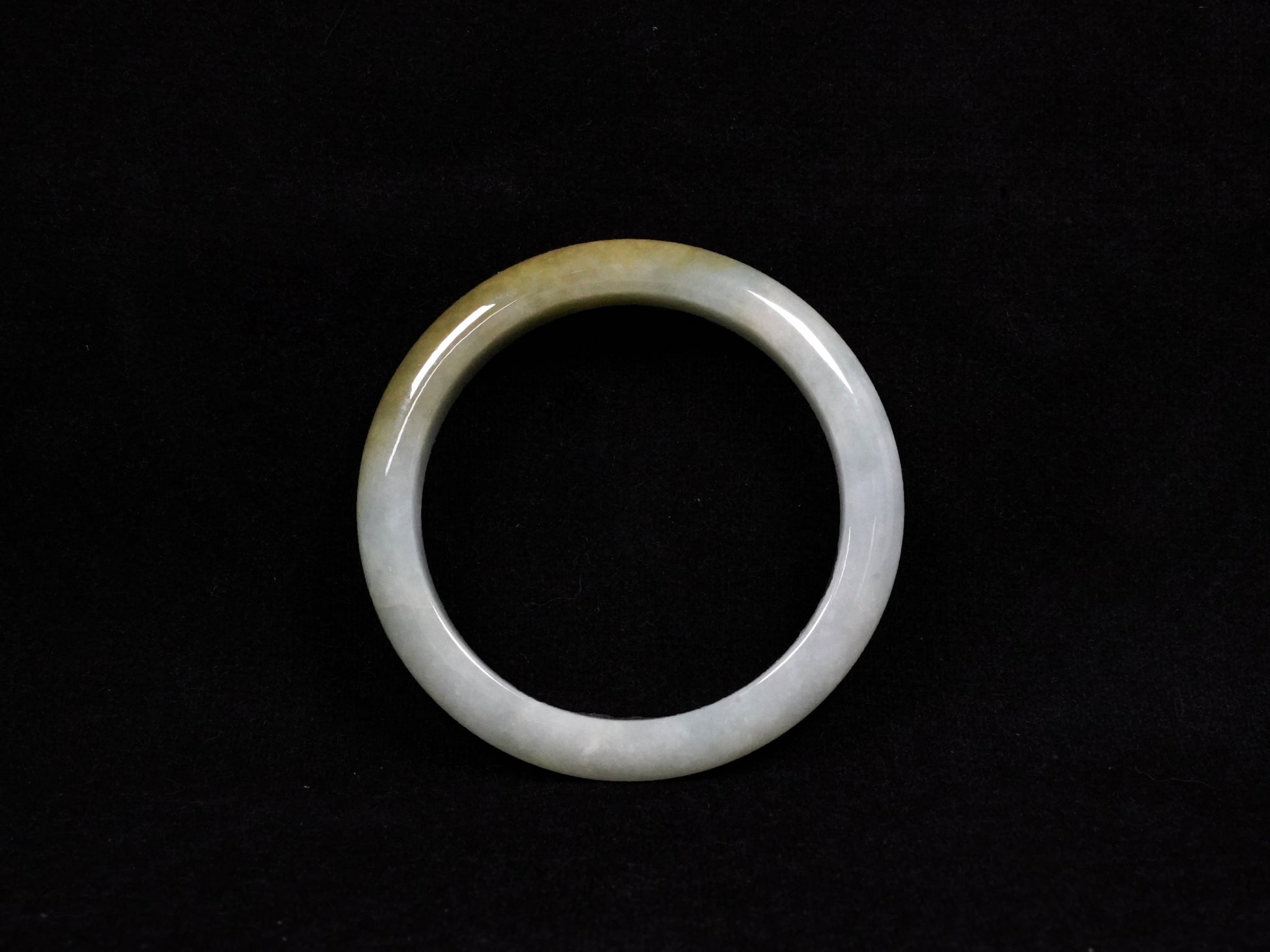 This jadeite bangle features a graceful gradient from fresh green to warm yellow.
