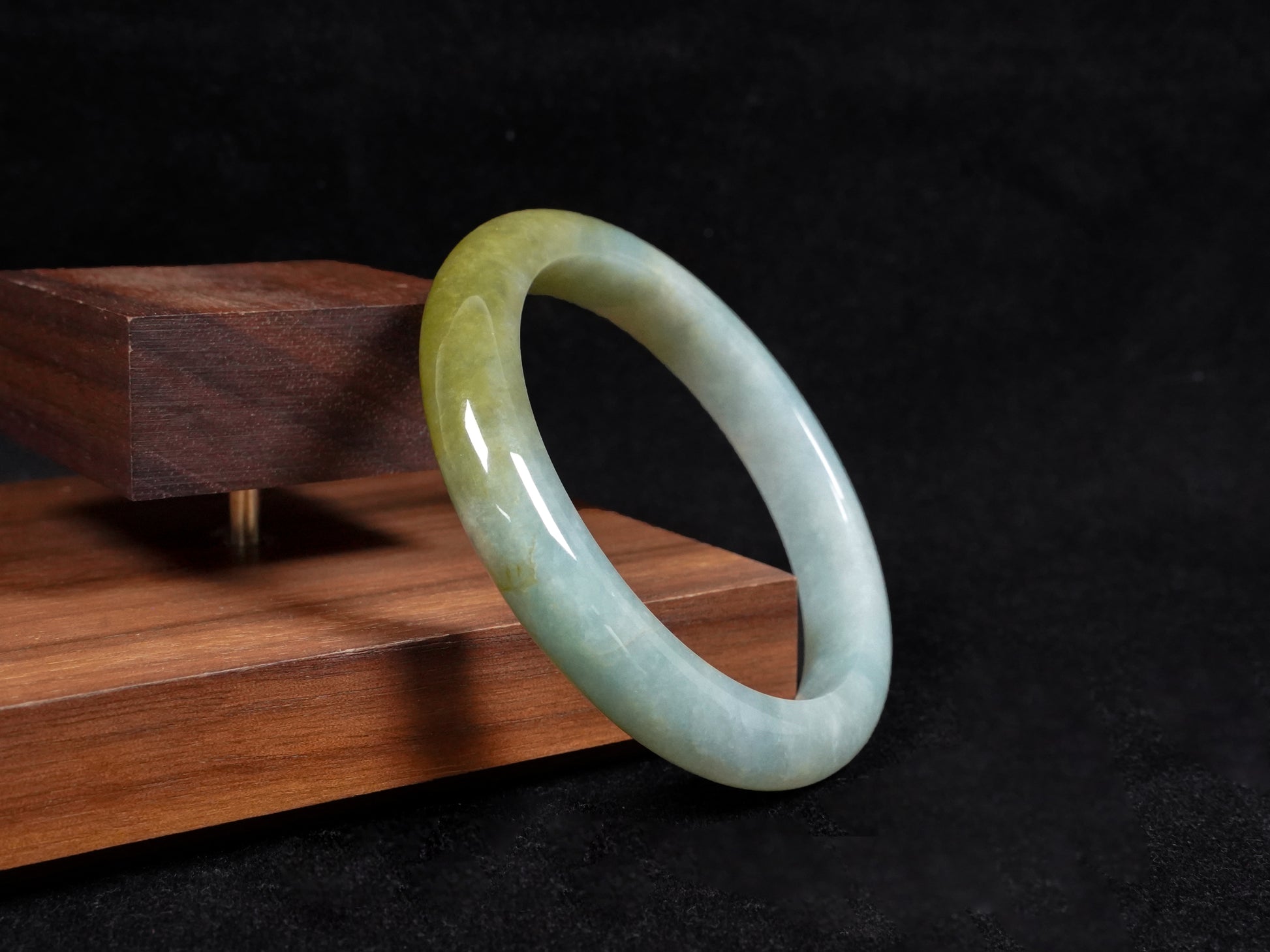 This jadeite bangle features a graceful gradient from fresh green to warm yellow.
