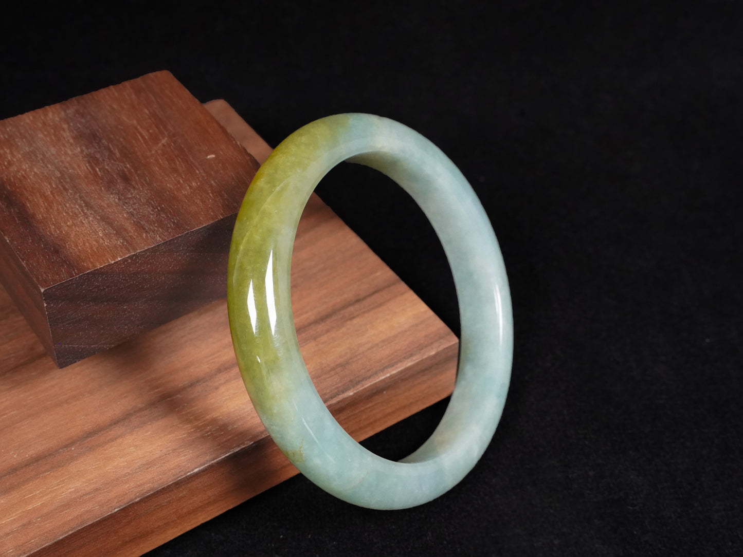 This jadeite bangle features a graceful gradient from fresh green to warm yellow.
