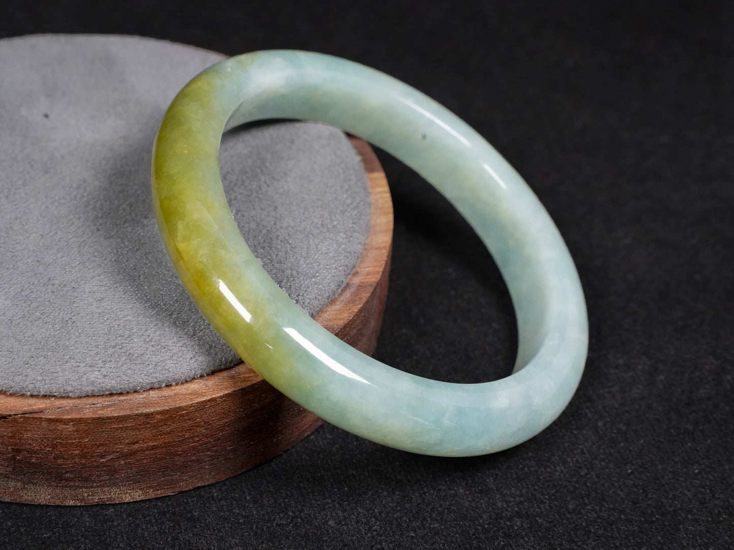 This jadeite bangle features a graceful gradient from fresh green to warm yellow.