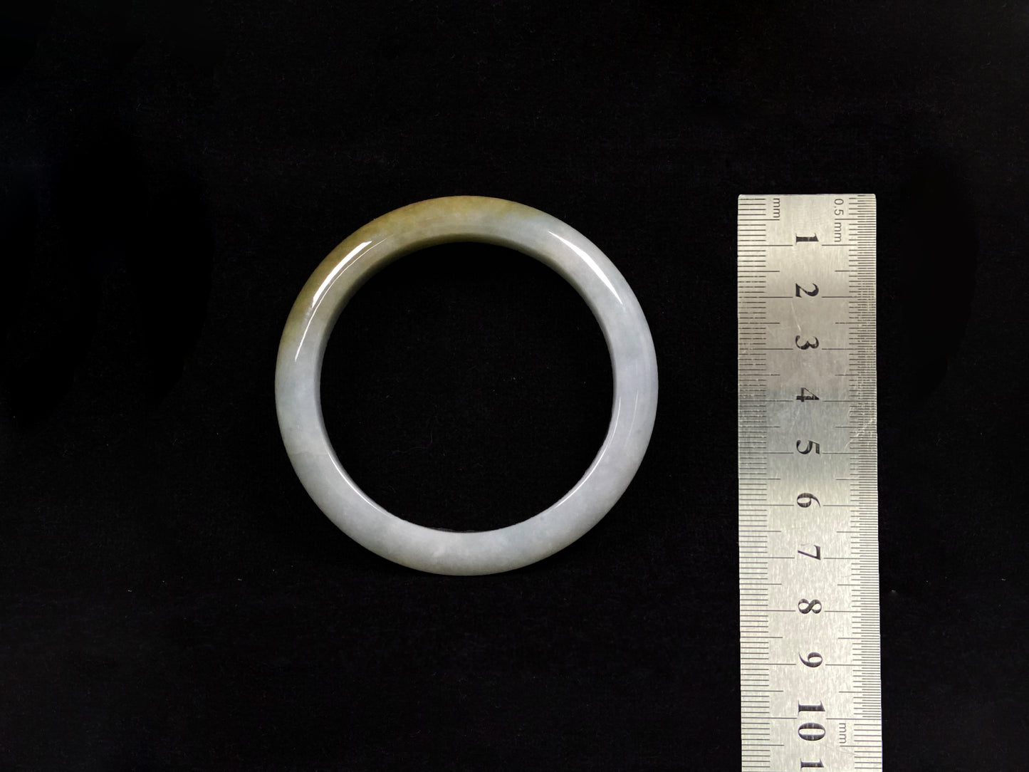 This jadeite bangle features a graceful gradient from fresh green to warm yellow.