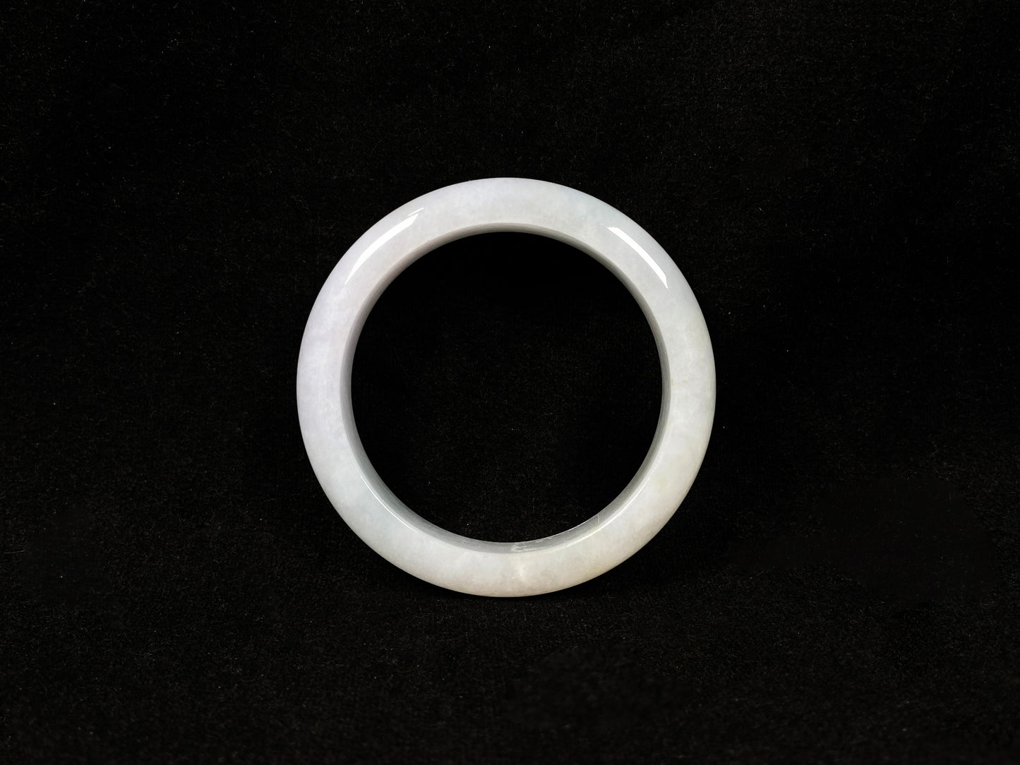 This creamy white jadeite bangle carries soft golden undertones, exuding warmth and elegance.