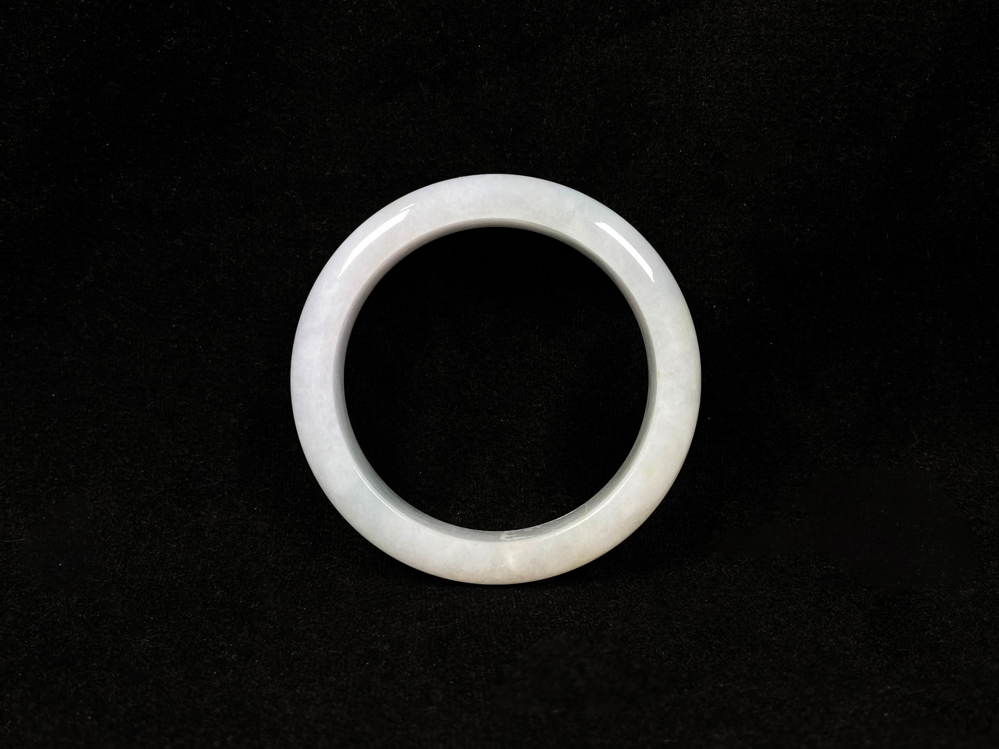This creamy white jadeite bangle carries soft golden undertones, exuding warmth and elegance.