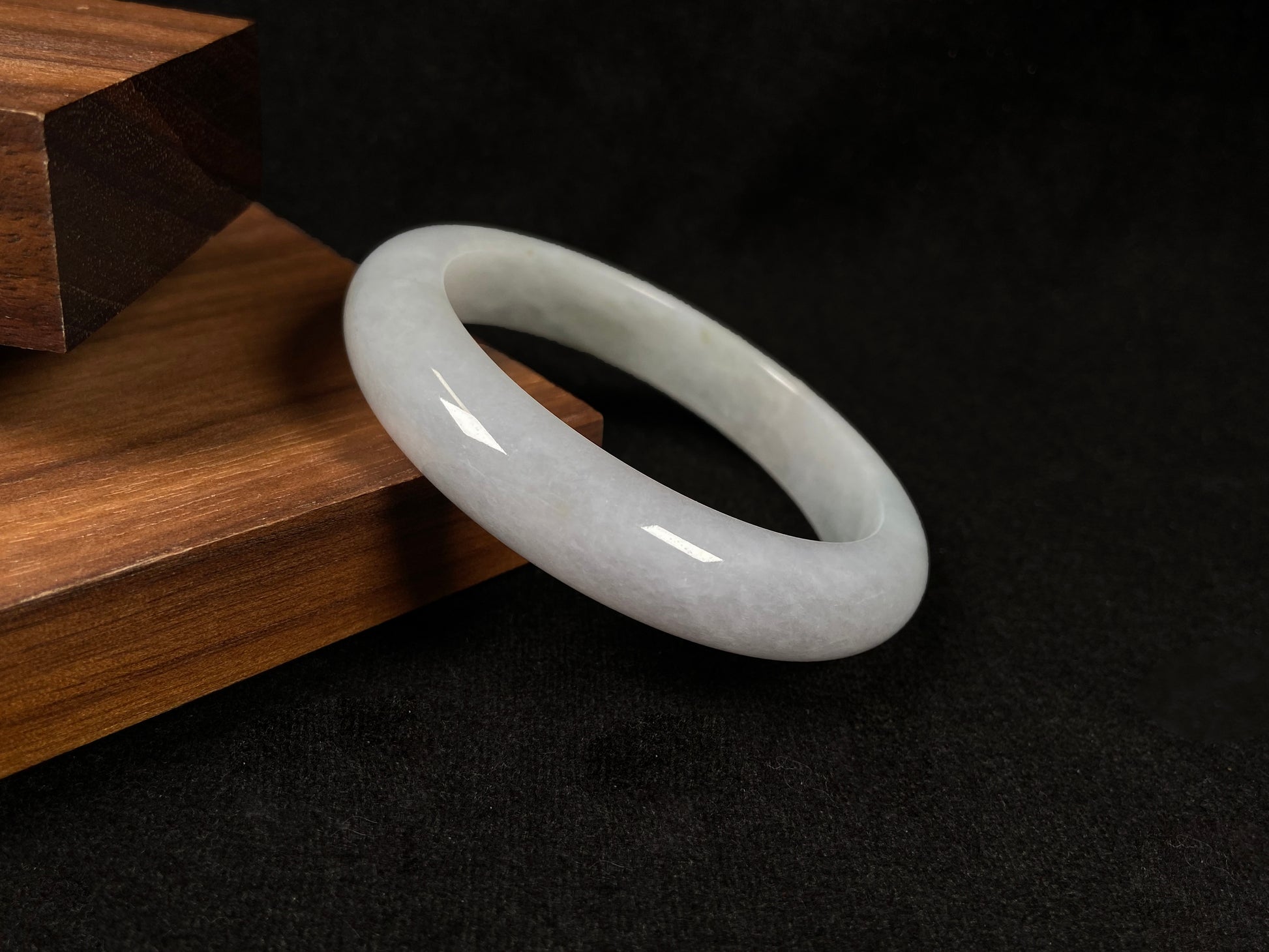 This creamy white jadeite bangle carries soft golden undertones, exuding warmth and elegance.