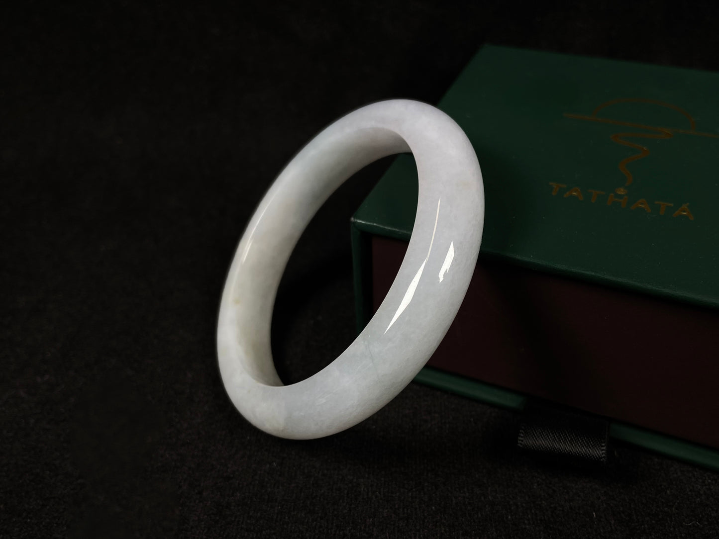 This creamy white jadeite bangle carries soft golden undertones, exuding warmth and elegance.