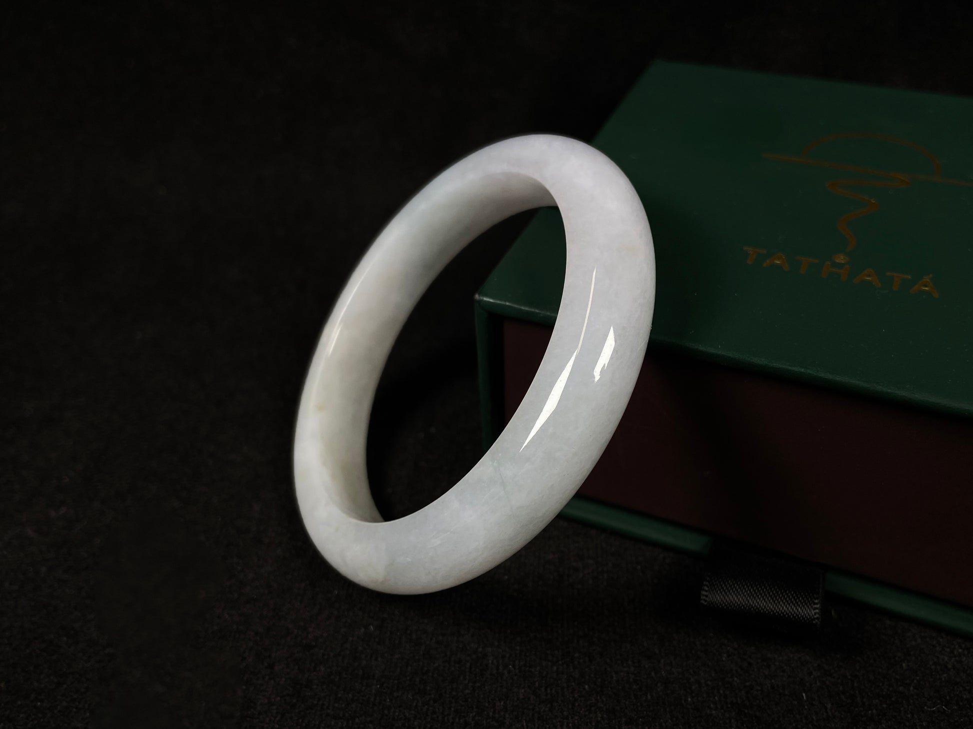 This creamy white jadeite bangle carries soft golden undertones, exuding warmth and elegance.